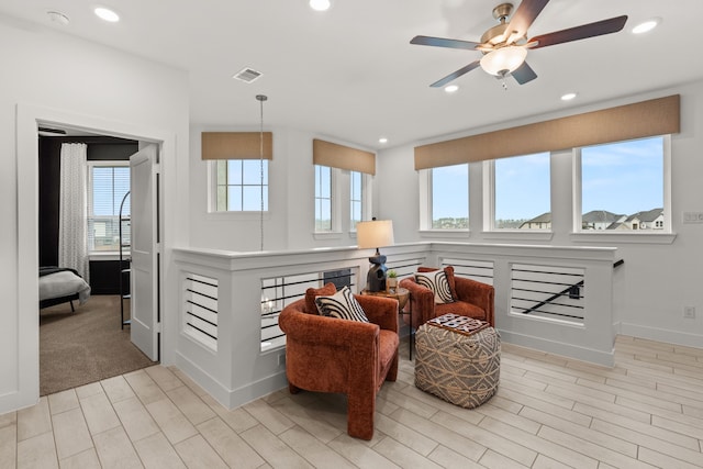 living area with a wealth of natural light, visible vents, a ceiling fan, and recessed lighting