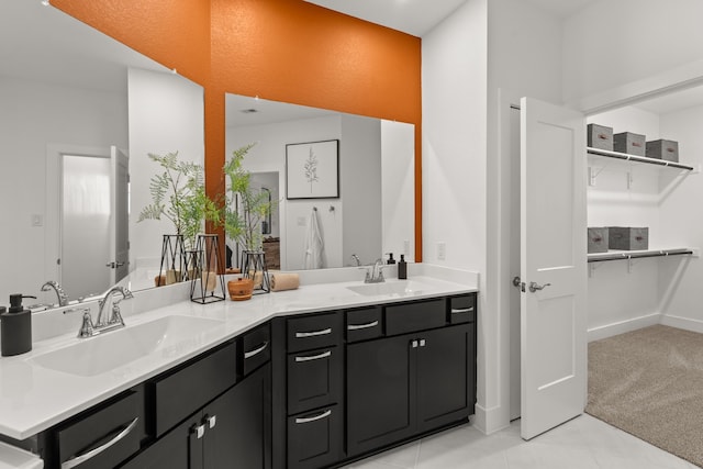 full bathroom featuring double vanity, a sink, tile patterned floors, and baseboards