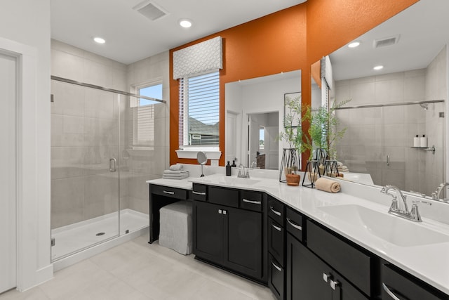 bathroom featuring tile patterned flooring, a sink, a shower stall, and visible vents