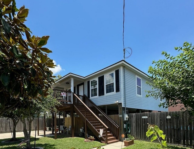 view of front of property with a front yard, a patio, stairway, and fence private yard