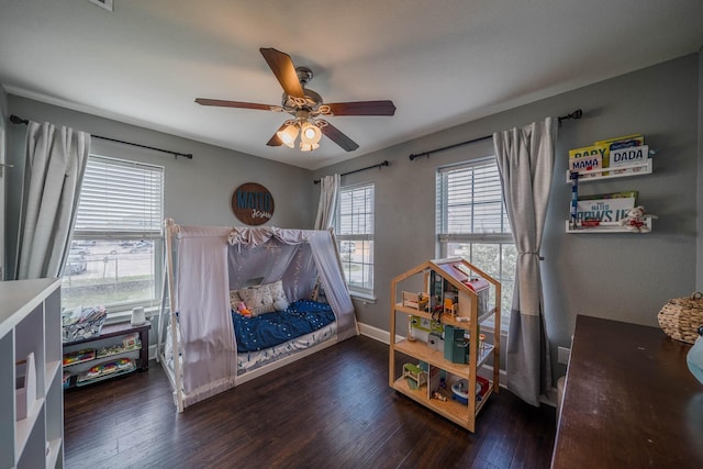 bedroom with baseboards, dark wood-type flooring, and a ceiling fan