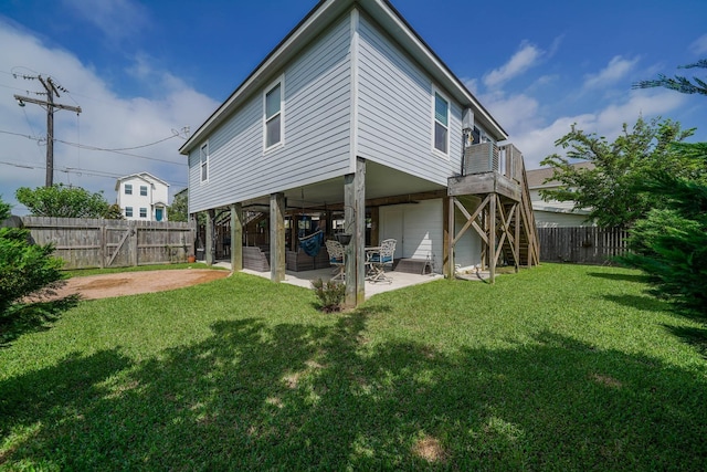back of house with a fenced backyard, a lawn, stairway, and a patio area