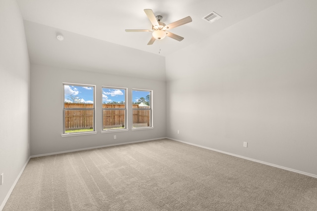 spare room featuring vaulted ceiling, baseboards, carpet floors, ceiling fan, and visible vents