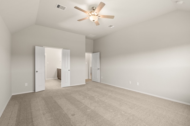 unfurnished bedroom featuring baseboards, lofted ceiling, visible vents, and light colored carpet