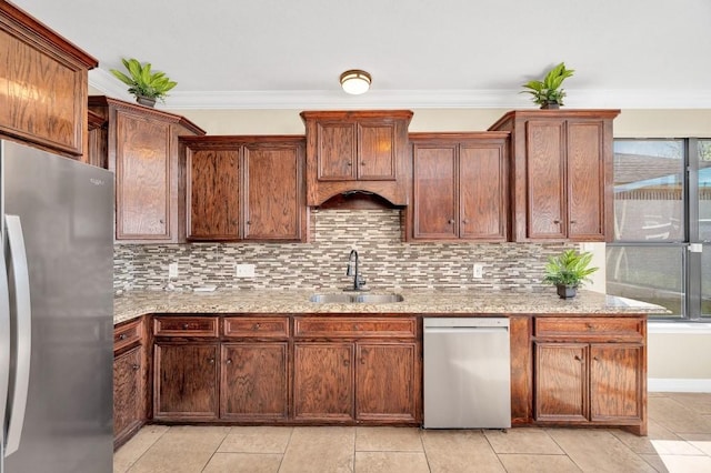 kitchen with decorative backsplash, crown molding, stainless steel appliances, a sink, and light stone counters