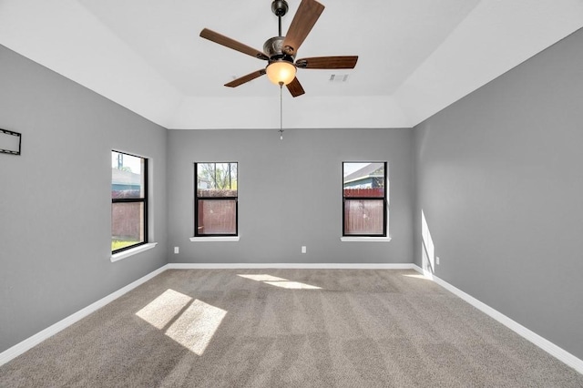 spare room with baseboards, carpet floors, a raised ceiling, and a ceiling fan