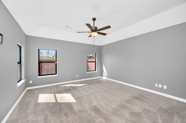 carpeted spare room featuring baseboards, visible vents, lofted ceiling, and ceiling fan