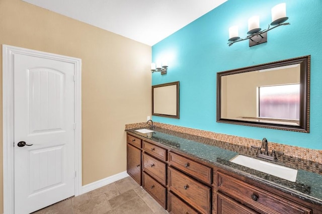 bathroom featuring double vanity, a sink, and baseboards