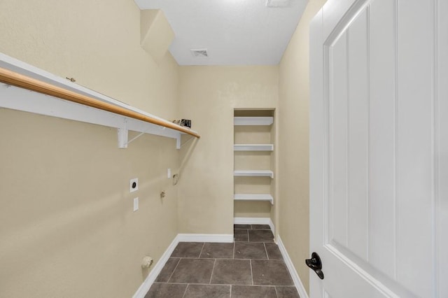 clothes washing area with hookup for a gas dryer, hookup for an electric dryer, laundry area, tile patterned flooring, and baseboards