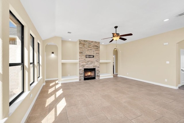 unfurnished living room featuring a ceiling fan, arched walkways, baseboards, and visible vents