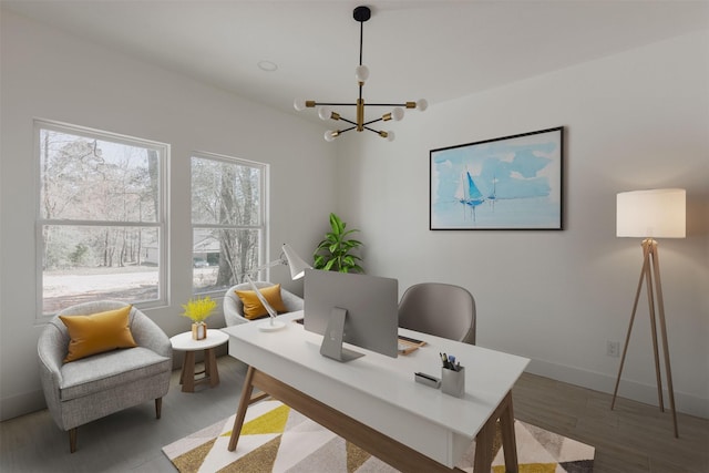 office area featuring baseboards, wood finished floors, and a notable chandelier