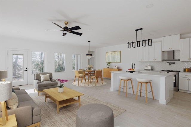 living room with light wood-type flooring and a ceiling fan