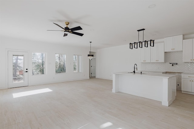 kitchen featuring plenty of natural light, light countertops, decorative backsplash, and a sink