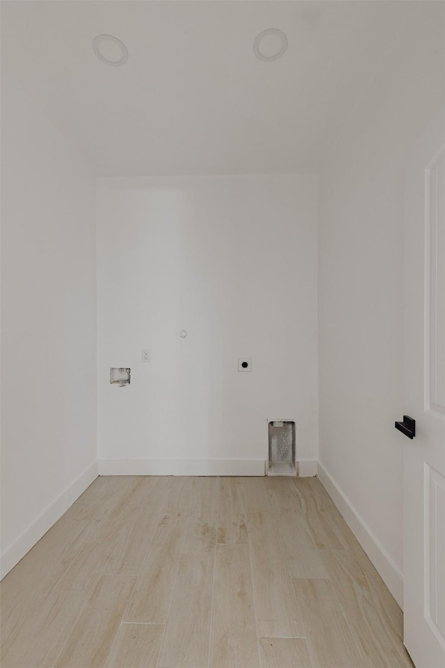 clothes washing area with hookup for an electric dryer, baseboards, light wood finished floors, and washer hookup
