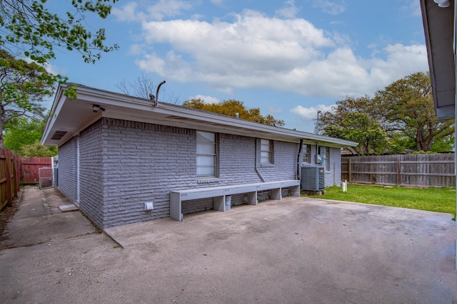 2821 1st Ave N, Texas City, TX 77590 - rear view of house featuring central AC, a fenced backyard, a yard, and a patio area