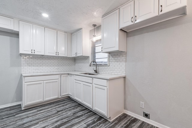 2821 1st Ave N, Texas City, TX 77590 - kitchen featuring white cabinetry, light countertops, baseboards, dark wood finished floors, and a sink