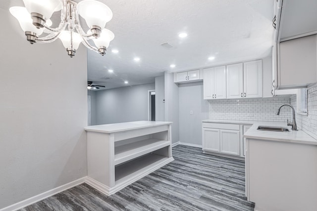 2821 1st Ave N, Texas City, TX 77590 - kitchen featuring decorative backsplash, white cabinets, light countertops, wood finished floors, and a sink