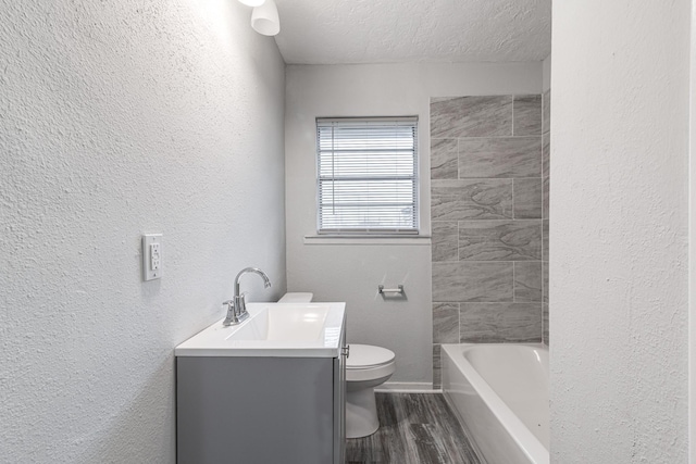 2821 1st Ave N, Texas City, TX 77590 - bathroom featuring vanity, toilet, a textured wall, a textured ceiling, and wood finished floors