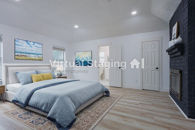 2902 Misty Park Dr, Houston, TX 77082 - bedroom featuring light wood finished floors, a brick fireplace, recessed lighting, ensuite bathroom, and baseboards