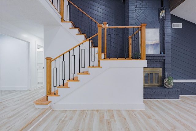 2902 Misty Park Dr, Houston, TX 77082 - staircase featuring wood finished floors, an outdoor brick fireplace, baseboards, and a high ceiling