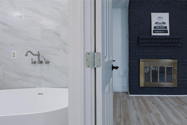 2902 Misty Park Dr, Houston, TX 77082 - full bathroom featuring a freestanding tub, a fireplace, and wood finished floors