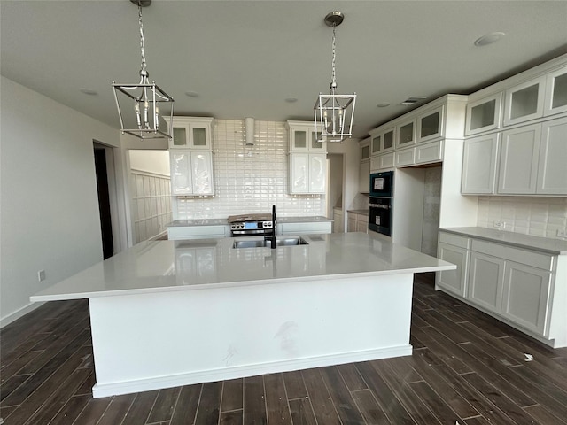 6215 Amberwood Dr, League City, TX 77573 - kitchen with a chandelier, oven, a spacious island, decorative backsplash, and light countertops