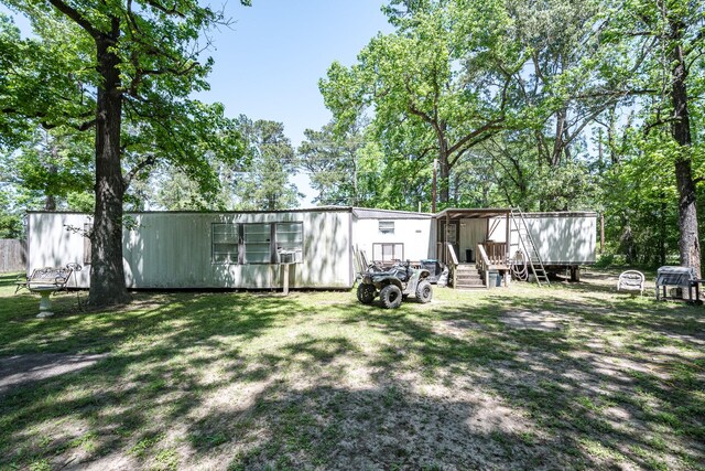 25528 Ipes Rd, Splendora, TX 77372 - rear view of property with an outbuilding and a yard