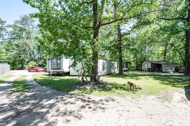 25528 Ipes Rd, Splendora, TX 77372 - view of yard featuring driveway, fence, and an outbuilding
