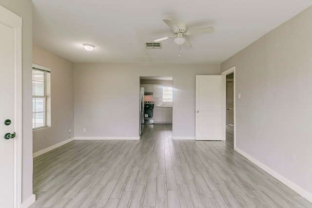 5009 Bataan Rd, Houston, TX 77033 - empty room featuring baseboards, light wood-style floors, ceiling fan, and visible vents