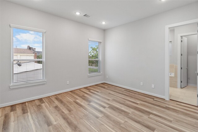 spare room with baseboards, light wood-style floors, visible vents, and recessed lighting