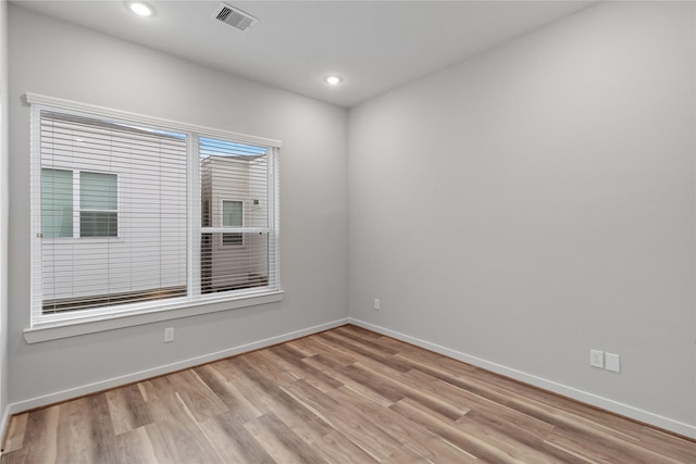 spare room with recessed lighting, wood finished floors, visible vents, and baseboards