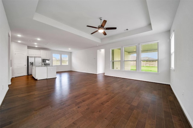 29026 Zacate Creek Ln, Fulshear, TX 77441 - unfurnished living room with a tray ceiling, a ceiling fan, dark wood finished floors, baseboards, and recessed lighting