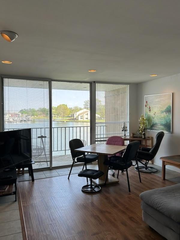 12600 Melville Dr Unit 214A, Montgomery, TX 77356 - dining room featuring a water view, a wall of windows, and wood finished floors