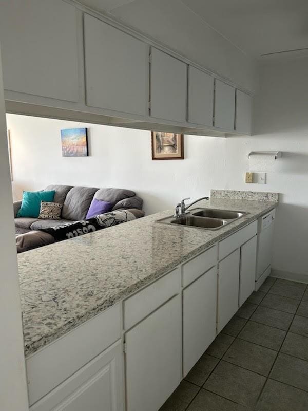 12600 Melville Dr Unit 214A, Montgomery, TX 77356 - kitchen with white cabinets, dark tile patterned floors, a sink, and dishwasher