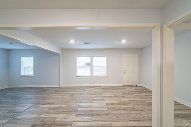empty room featuring baseboards, light wood finished floors, and visible vents