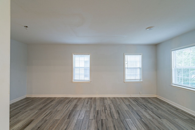 spare room featuring dark wood finished floors and baseboards