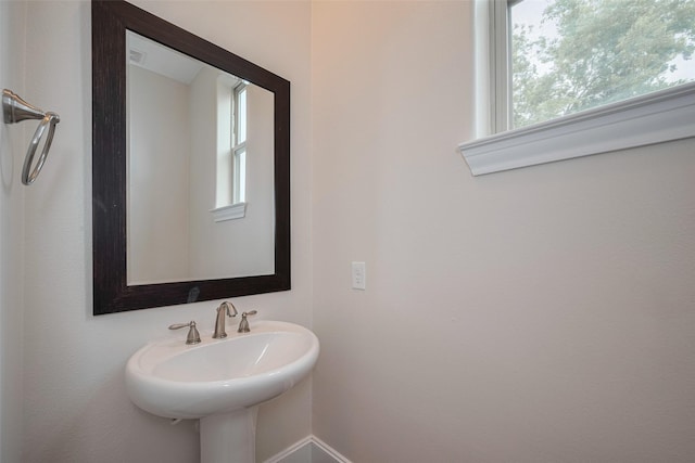 bathroom featuring baseboards and a sink