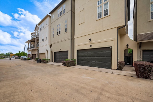 view of property featuring concrete driveway and a garage