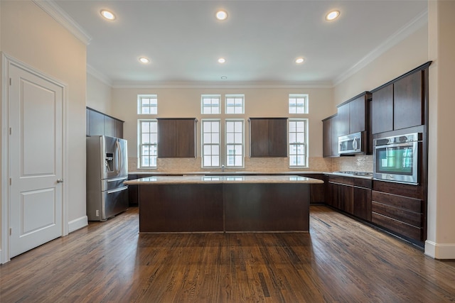 kitchen with a kitchen island, dark brown cabinets, appliances with stainless steel finishes, and dark wood-type flooring