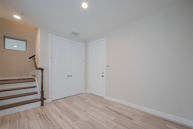 foyer entrance with visible vents, stairs, baseboards, light wood finished floors, and recessed lighting