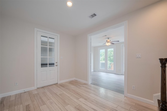 spare room featuring visible vents, light wood-style flooring, ceiling fan, and baseboards