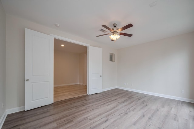 unfurnished room with a ceiling fan, baseboards, visible vents, and wood finished floors