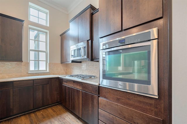 kitchen featuring crown molding, light countertops, dark brown cabinetry, and stainless steel appliances
