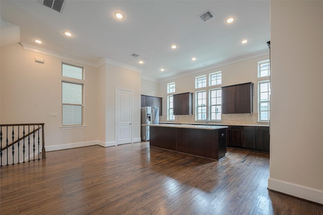 kitchen with a kitchen island, dark brown cabinetry, visible vents, and stainless steel fridge with ice dispenser