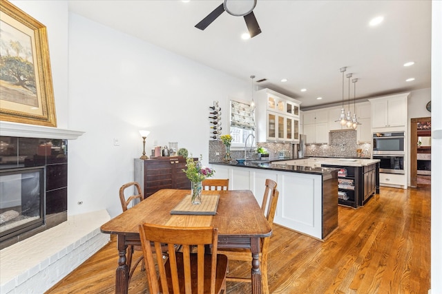 1101 Heights Blvd, Houston, TX 77008 - dining area featuring a ceiling fan, wood finished floors, a tile fireplace, and recessed lighting