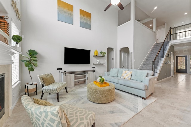 7611 Mesquite Hill Ln, Richmond, TX 77469 - tiled living area with a high ceiling, a premium fireplace, stairs, ceiling fan, and healthy amount of natural light