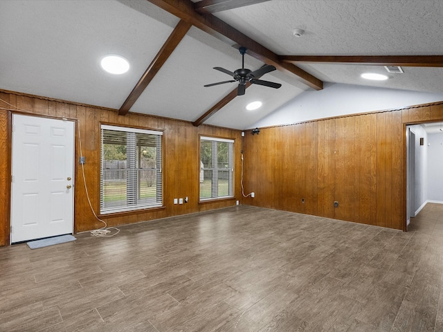 314 Lantana Dr, Texas City, TX 77591 - unfurnished living room featuring a textured ceiling, wooden walls, ceiling fan, vaulted ceiling with beams, and wood finished floors