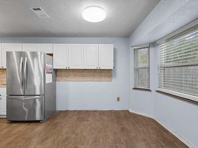 314 Lantana Dr, Texas City, TX 77591 - kitchen featuring visible vents, wood finished floors, white cabinetry, and freestanding refrigerator