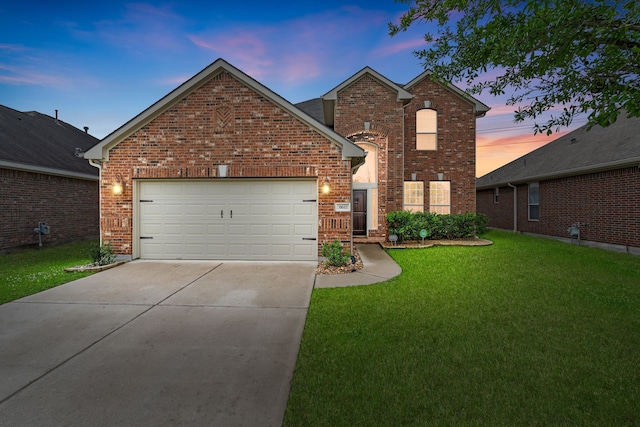 traditional-style home featuring a yard, brick siding, driveway, and a garage