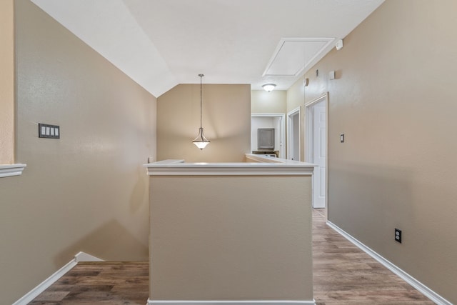 interior space with attic access, baseboards, an upstairs landing, wood finished floors, and lofted ceiling